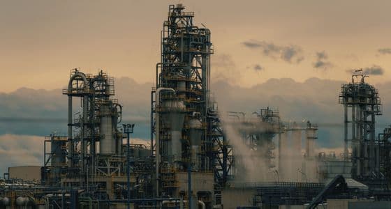 Distillation towers and pipework at an oil and gas refinery at dusk