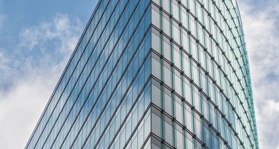 The glass facade of a modern commercial office building
